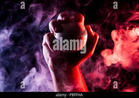 Close up of a white baseball ball in multi-colored red smoke from a vape on  a black isolated background Stock Photo - Alamy