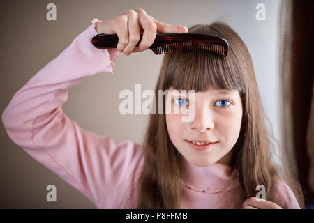 A Little Girl With Freckles And Blue Eyes With Scissors Cuts Her