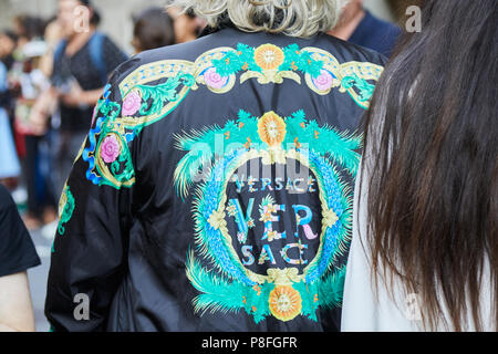 MILAN - JUNE 16: Man with Versace bomber jacket with green and golden decorations before Versace fashion show, Milan Fashion Week street style on June Stock Photo