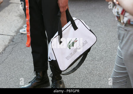 unse Postbud Stifte bekendtskab MILAN - JUNE 17: Man with white and black Lacoste bag before Prada fashion  show, Milan Fashion Week street style on June 17, 2018 in Milan Stock Photo  - Alamy