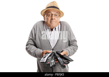 Confused elderly man with remotes isolated on white background Stock Photo