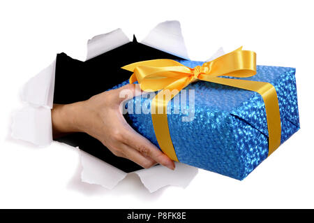 Man hand delivering or giving gift through torn white paper background Stock Photo