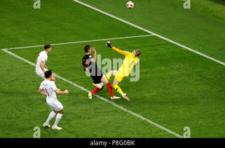 England goalkeeper Jordan Pickford (right) saves from a shot by Croatia's Mario Mandzukic (left) during the FIFA World Cup, Semi Final match at the Luzhniki Stadium, Moscow. Stock Photo