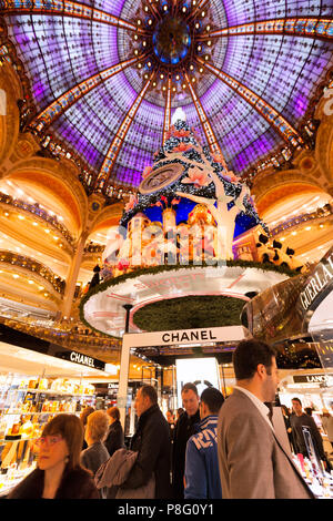 PARIS-DEC 24, 2013: Christmas shoppers crowd the aisles at the Galleries Lafayette, the city's famous department store. Stock Photo