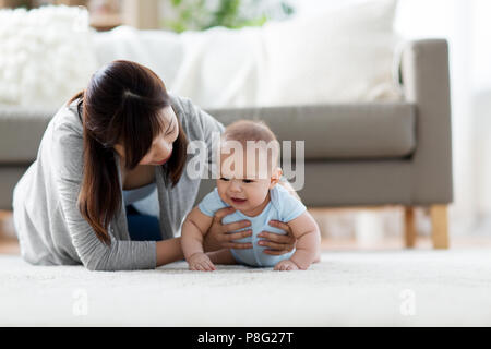 mother with crying little baby boy at home Stock Photo