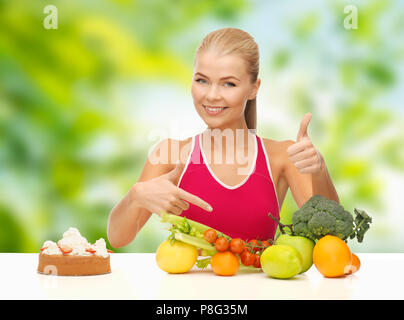 woman choosing between vegetable food and cake Stock Photo