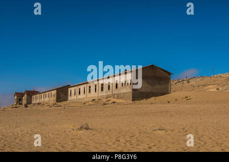 Row of abandoned buildings in ghost town of former diamond mining community of Kolmanskop near Luderitz in the Namib Desert of Namibia Stock Photo