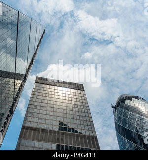 Looking up at a textured sky above three London landmark skyscrapers: The Leadenhall Building, 10 St Mary Axe and St Helen's. England, UK Stock Photo