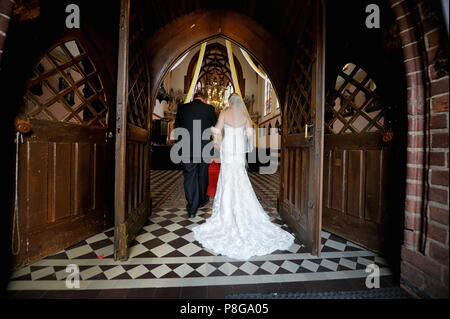 Bride walking down aisle with her father Stock Photo