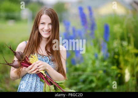 Young beautiful woman holding fresh organic vegetables Stock Photo