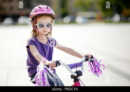 Adorable girl riding a bike on beautiful summer day Stock Photo