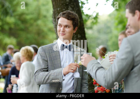 Wedding guests toasting happy bride and groom Stock Photo