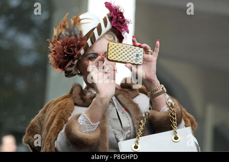 Hoppegarten, Germany, elegantly dressed woman takes a picture with her smartphone