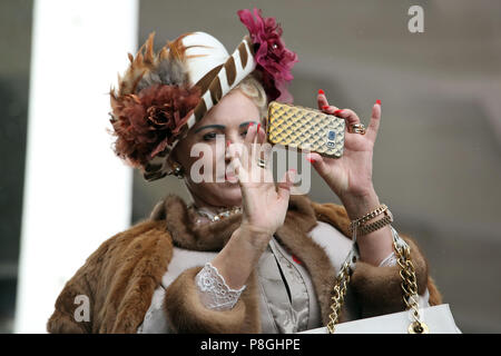 Hoppegarten, Germany, elegantly dressed woman takes a picture with her smartphone