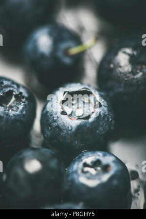 Fresh blueberry texture, wallpaper and background. Wet dark forest blueberries on dark background, selective focus, vertical composition, close-up. Su Stock Photo