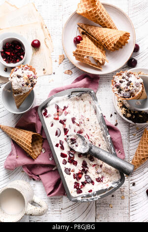 No churn vanilla ice cream with dark chocolate and cherry chunks in waffle cones. Stock Photo