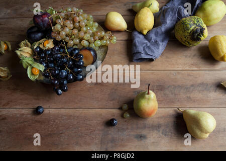 Seasonal autumn fruit on rustic wooden background Stock Photo