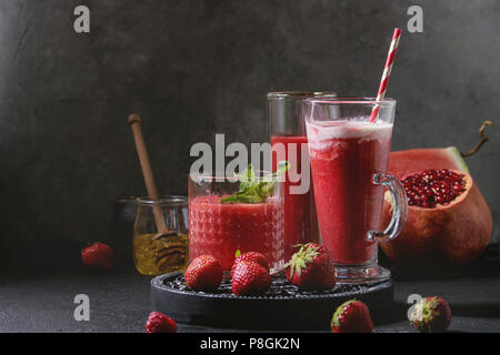 Three different red fruit berry watermelon, strawberry, raspberry, pomegranate cocktails or smoothies in glasses with crushed ice, mint and ingredient Stock Photo