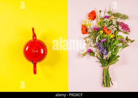 Wild flower bouquet and teapot, flat lay, top view. Herbal tea and healthy food concept Stock Photo