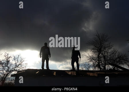 Berlin, Germany, Silhouette, craftsman standing on the roof of a gazebo Stock Photo