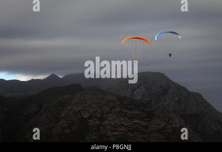 A couple paragliding on a stormy afternoon