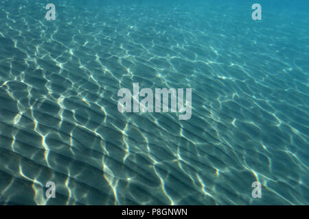 Underwater image of sea sand with beautiful blue water on a tropical bay. Stock Photo
