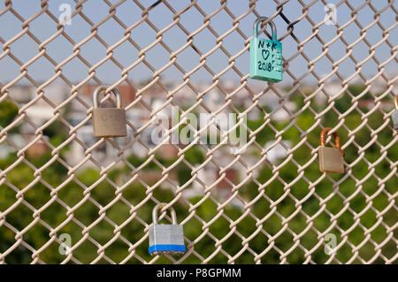 Locks signifying a couples love for one another on a bridge's chain fence in Pittsburgh, Pennsylvania, USA with a blurred background Stock Photo