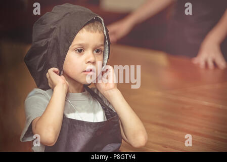 Little chef. The boy in the head chef and his face in flour Stock Photo