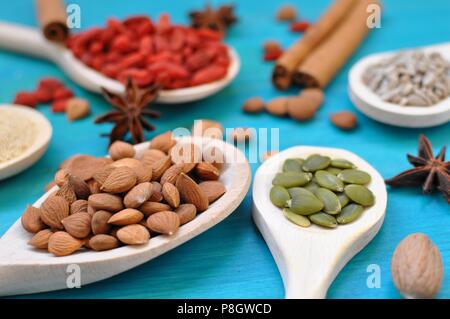 Concept of table with aromatic seeds and fruits in wooden spoons on blue background, close up, selective focus Stock Photo
