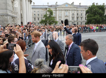 Dublin. 12th July, 2018. Britain's Prince Harry (1st L, inside the fence) and his wife Meghan Markle meet with the public at the Trinity College Dublin in Dublin, Ireland, July 11, 2018. Britain's Prince Harry and his wife Meghan Markle on Wednesday wrapped up a two-day visit to Ireland, the first official overseas visit ever paid by the royal couple since their marriage in May. Credit: Xinhua/Alamy Live News Stock Photo