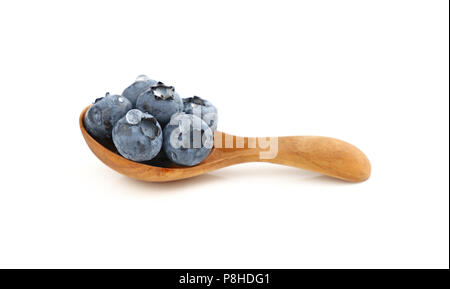 Close up several fresh washed blueberry berries with water drops in one rustic natural wooden scoop spoon isolated on white background, low angle view Stock Photo