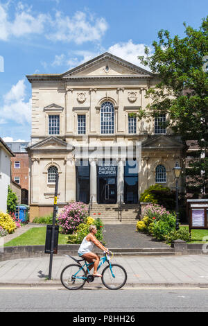 High Wycombe, UK - 3rd Lune 2018: A woman cyclist rides past the Union Baptist Church. It holds 2 services each Sunday. Stock Photo