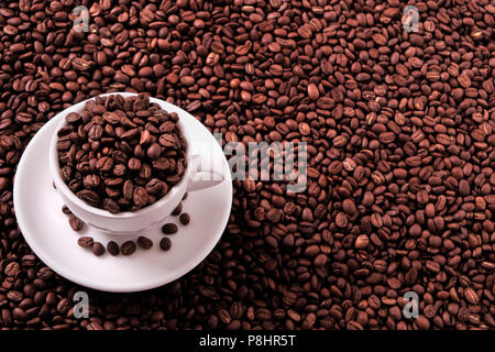 White coffee cup filled with roasted beans Stock Photo