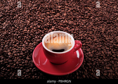 Red coffee cup with espresso and roasted beans background Stock Photo