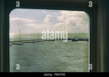 A look through the porthole of the ferry to moored yachts in the port of the Baltic Sea Stock Photo