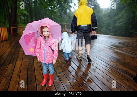 Adorable little girl at rainy day in autumn Stock Photo