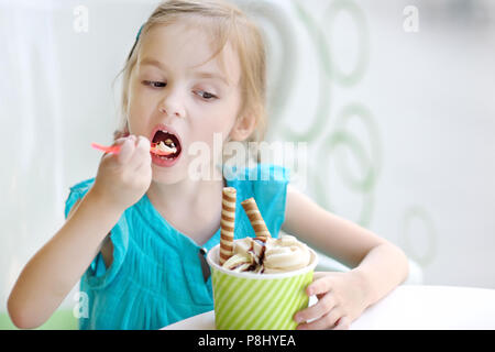 Adorable little girl eating ice cream at summer Stock Photo