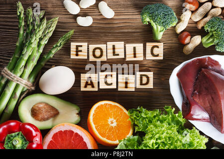 Natural sources of folic acid as liver, asparagus, broccoli, eggs, salad, avocado, paprika, nuts, orange, beetroots and beans Stock Photo