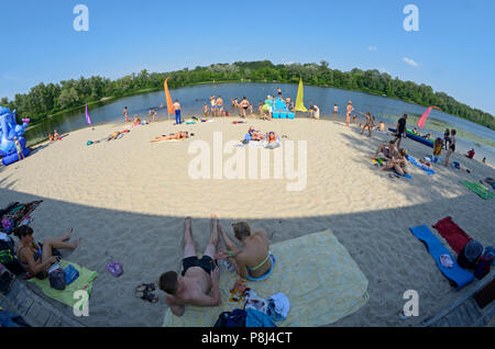 People relaxing on a beach near Zenit camping where festival of Yoga and Vedic Culture “Vedalife-2017, Island” was held. August 7, 2017. Kiev, Ukraine Stock Photo