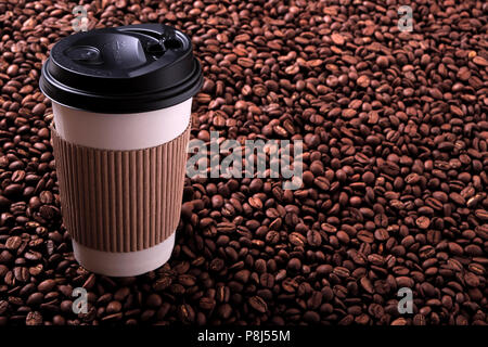 Takeaway coffee cup with roasted beans background Stock Photo
