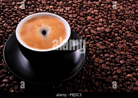 Black coffee cup with roasted beans background Stock Photo