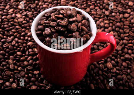 Red coffee mug filled with beans Stock Photo