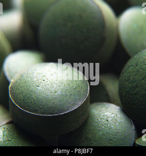 Blue green algae. Close up of natural organic spirulina tablets with focus at the foreground and blur effect Stock Photo