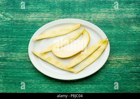 Yellow sliced melon fruit on plate. Top view. Stock Photo