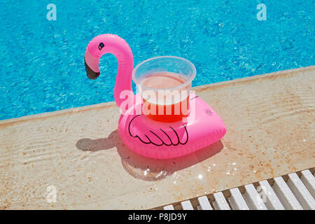 Float flamingo drink holder with beer in a pool party Stock Photo