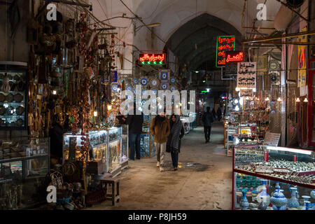 Shoppers walk along the covered walk ways past shops and traders in the Grand Bazaar or Qeysarriyeh Bazaar in Isfahan, Iran. It is one of the largest  Stock Photo