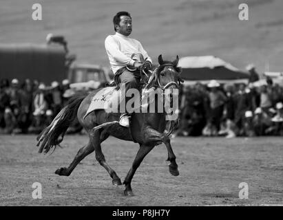 A Khampa participates in the dressage competition at the Litang Horse Festival in Kham - Sichuan Province, China, (Tibet) Stock Photo