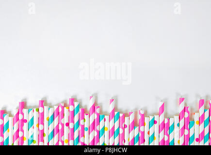 row of drinking straws with stripe and polka dot design border on white Stock Photo