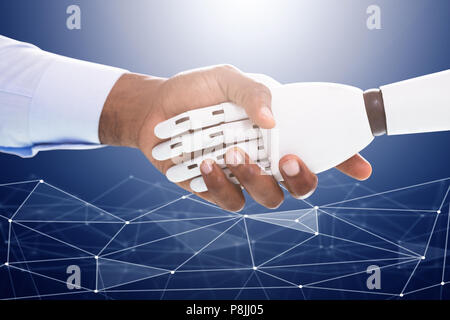 Robot And Businessman Shaking Hands Over The Digital Backdrop Stock Photo