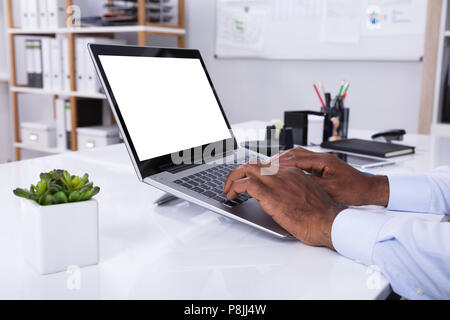 Close-up Of Man's Hand Typing On Laptop Over The White Desk Stock Photo